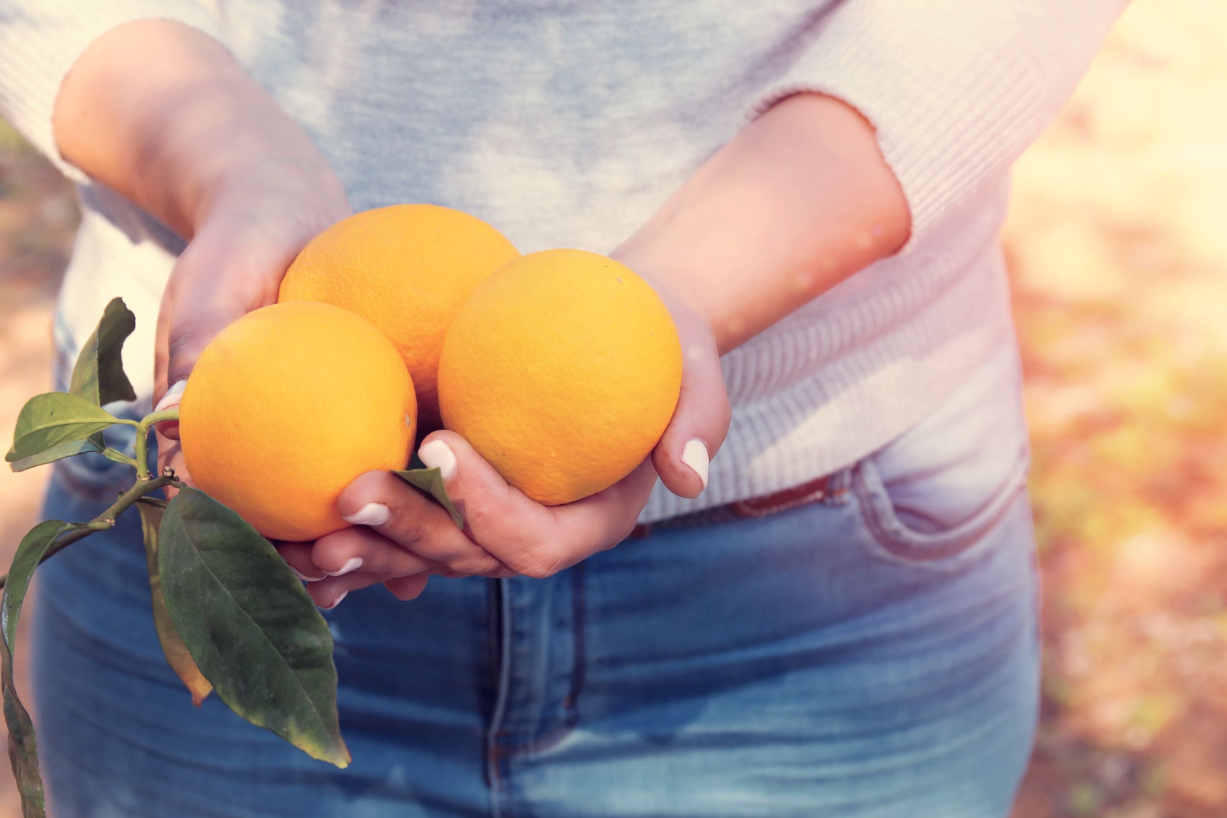 mujer con naranjas en la mano